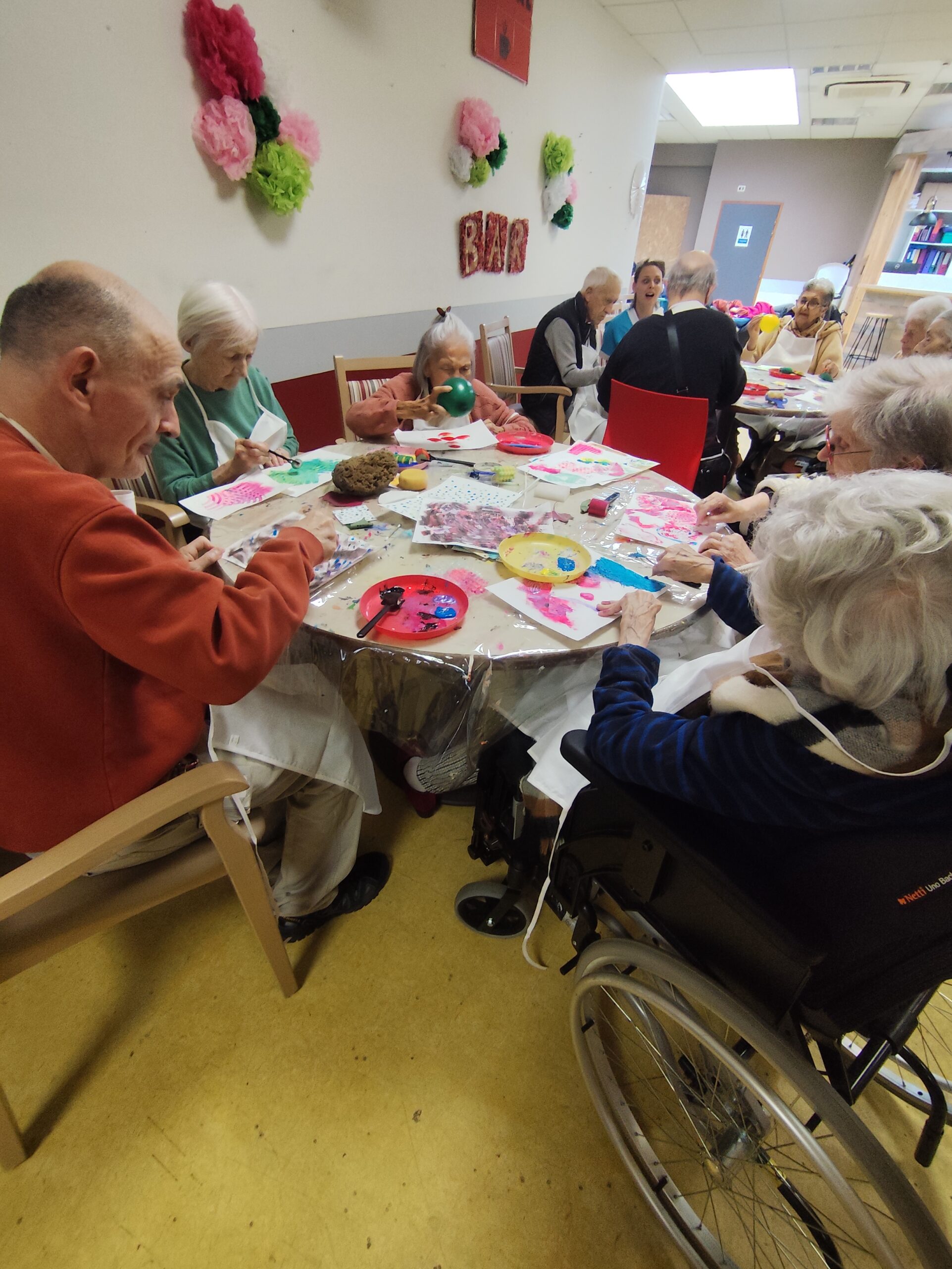 Personnes agées en fauteuil ou assis créant en coopération une oeuvre collective